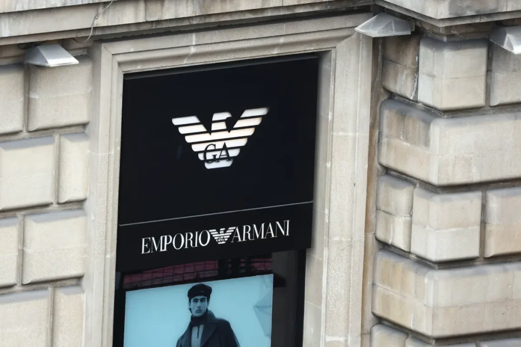 Emporio Armani Storefront Logo On Black Panel With Eagle Emblem, Luxury Fashion Signage On Stone Building.